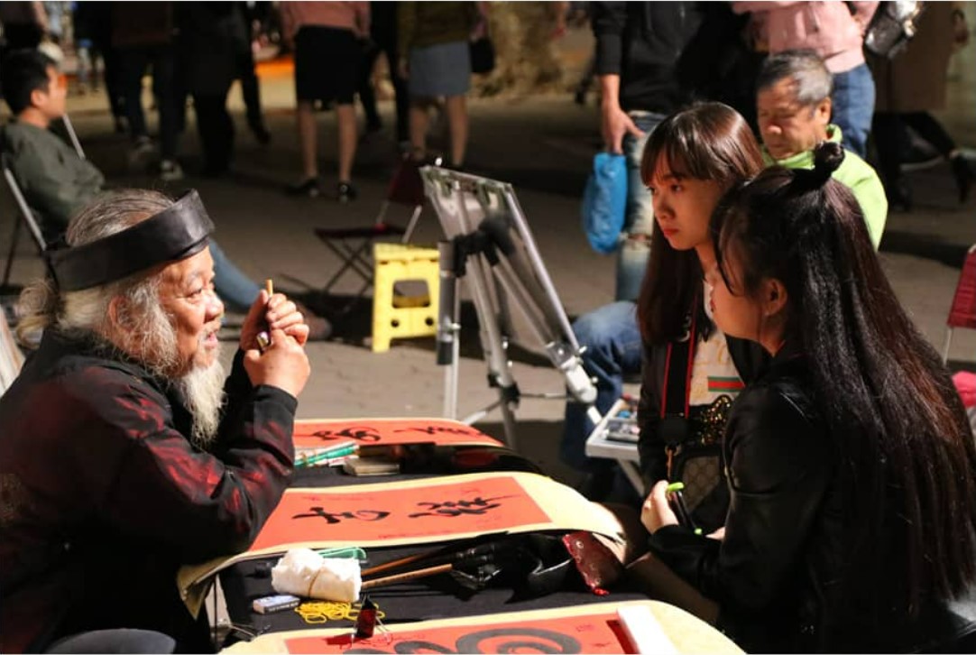 Visitors enjoy the experience of calligraphy